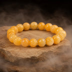 Yellow jade quartz bracelet with polished gemstone beads on natural stone display for elegant crystal energy