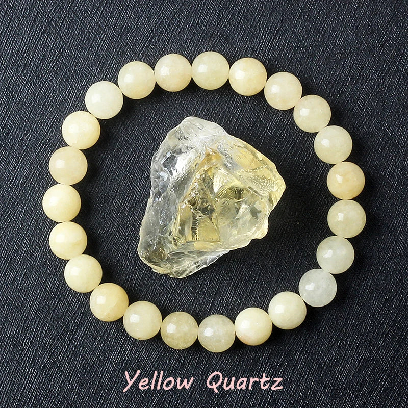 Yellow Quartz bracelet with soft pale cream beads surrounding a raw golden quartz specimen on dark background