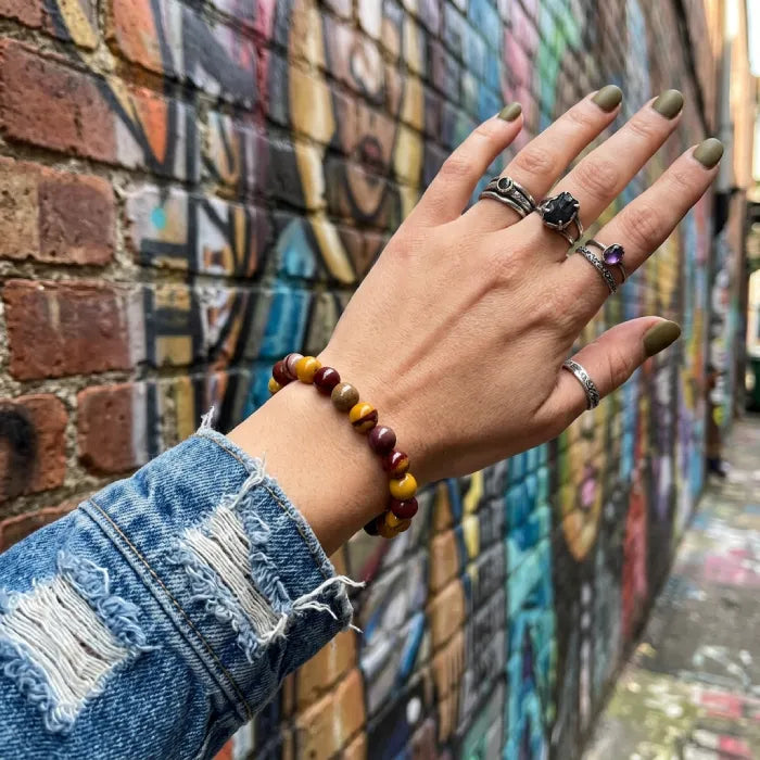 Yolk Stone Bracelet worn with denim outfit near graffiti wall, trendy crystal jewelry adding bold style and natural energy