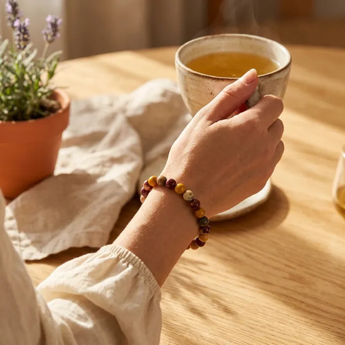 Yolk Stone Bracelet worn while holding tea cup, calming lifestyle jewelry promoting relaxation and mindful daily routine