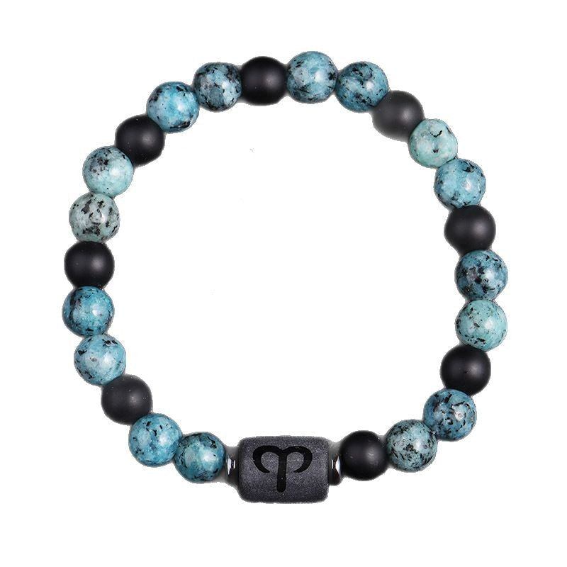 Zodiac bracelet, Aries option, with blue-green jasper, matte black onyx, hematite spacers, and a black Aries centerpiece, shown in a clear close focused full product view on white.