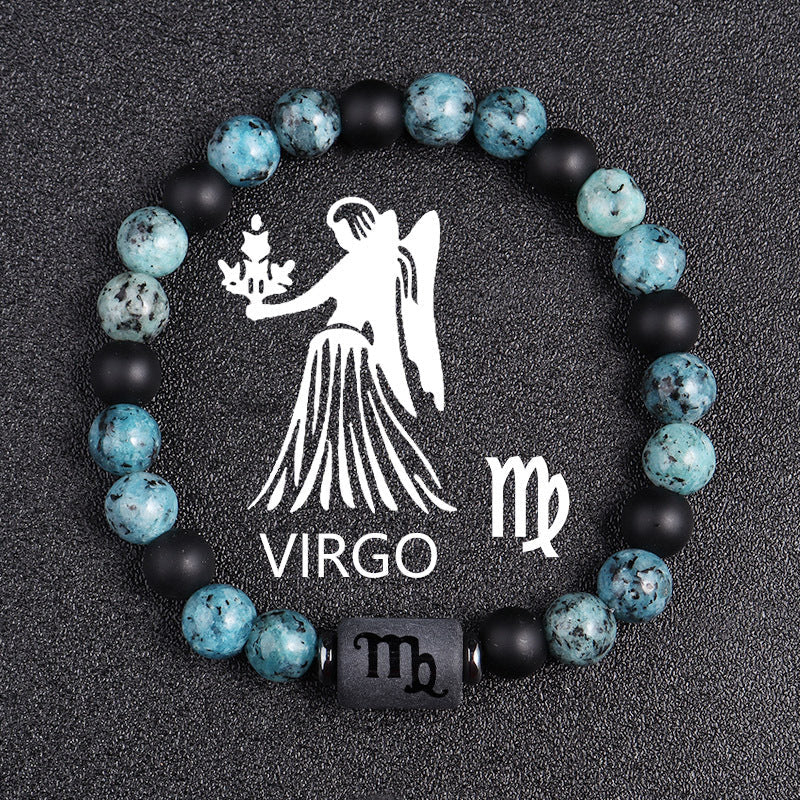 Zodiac bracelet, Virgo option, with blue-green jasper, matte black onyx, hematite spacers, and a black Virgo centerpiece, shown in a clear focused full product view on dark fabric.